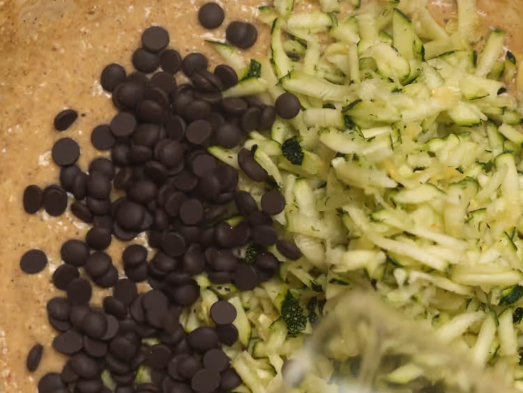 Fold-in-shredded-zucchini-and-chocolate-chips-gently,-without-overmixing