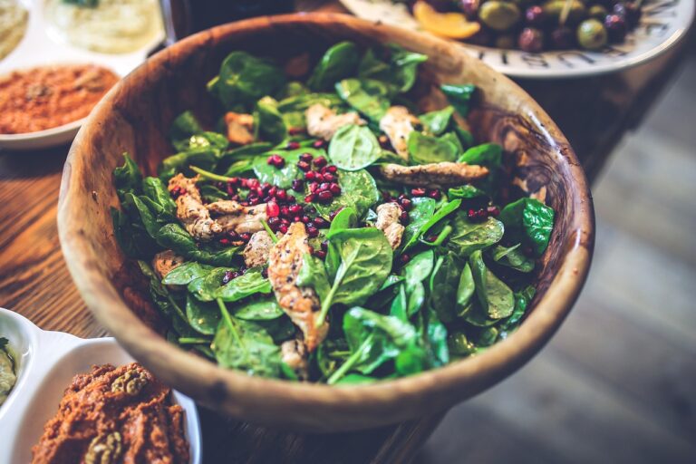 A healthy chicken salad bowl with spinach, pomegranate seeds, and chicken fillet in a wooden bowl - representing the protein and fiber-rich meals in a 5-day weight loss meal plan for women over 40