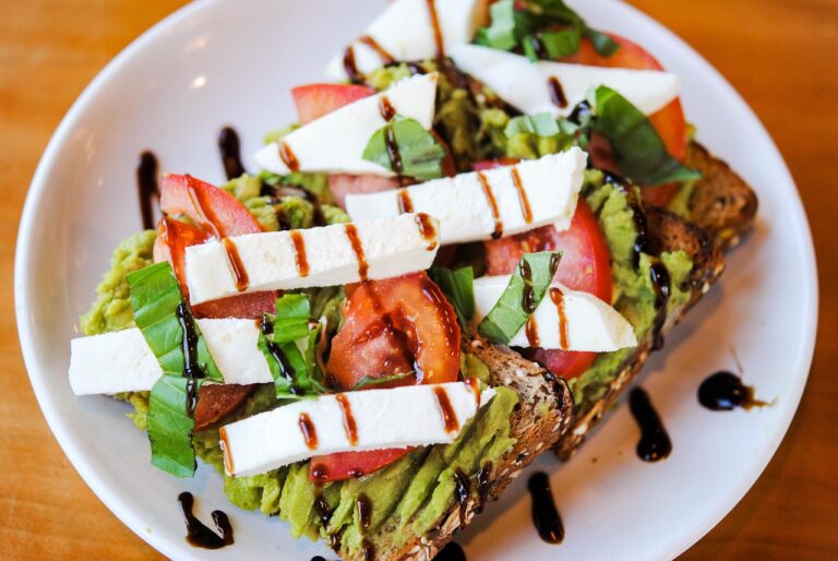 Savory avocado toast with fresh tomato, basil, and balsamic glaze on a plate - a quick egg-free PCOS-friendly breakfast idea