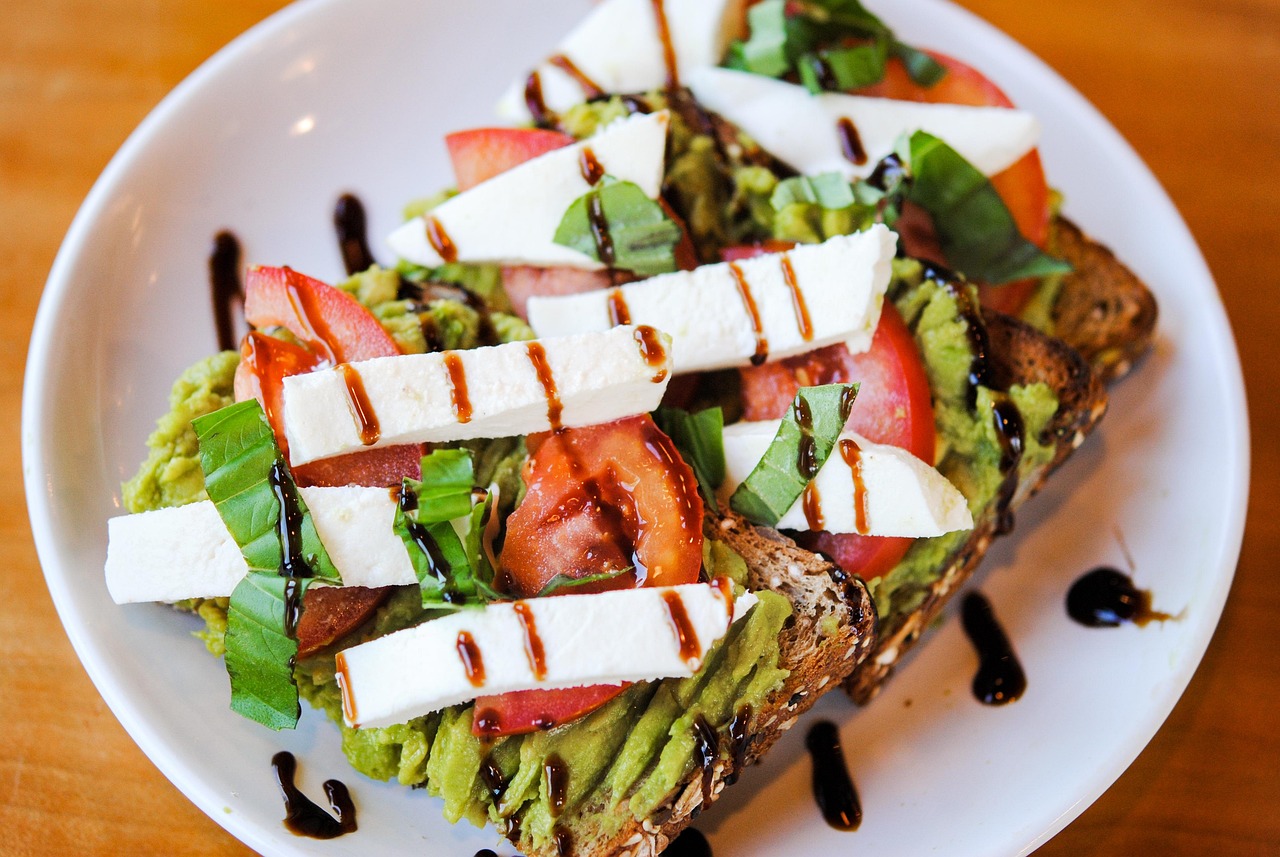 Savory avocado toast with fresh tomato, basil, and balsamic glaze on a plate - a quick egg-free PCOS-friendly breakfast idea