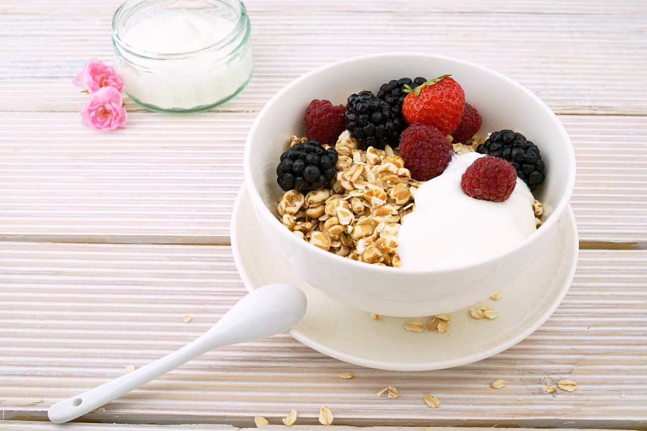A bowl of yogurt with berries, muesli, and granola representing probiotic and fiber-rich foods that help heal gut after antibiotics