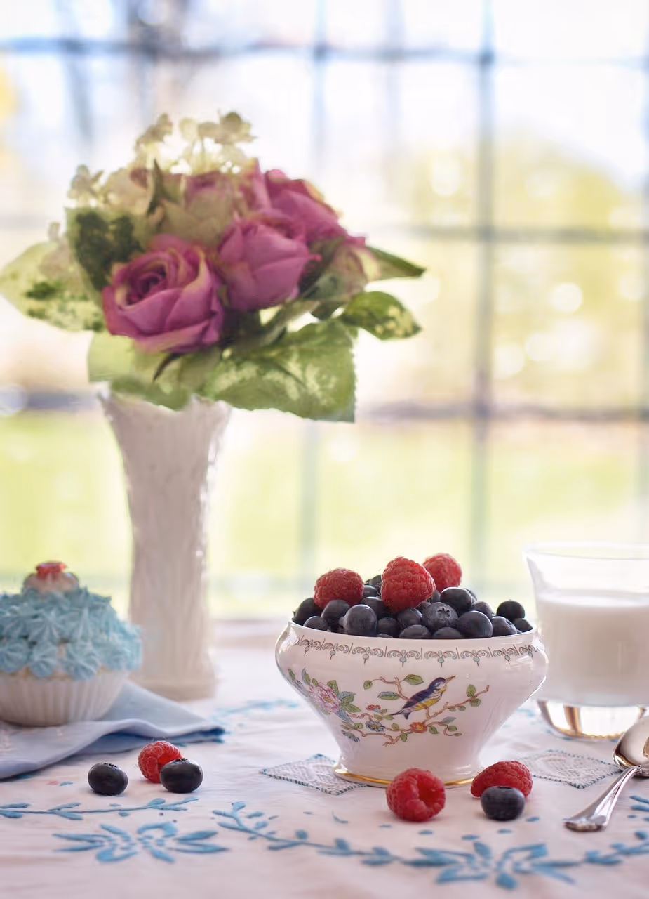 Bowl of fresh blueberries and raspberries on a wooden table - perfect for berry breakfast recipes