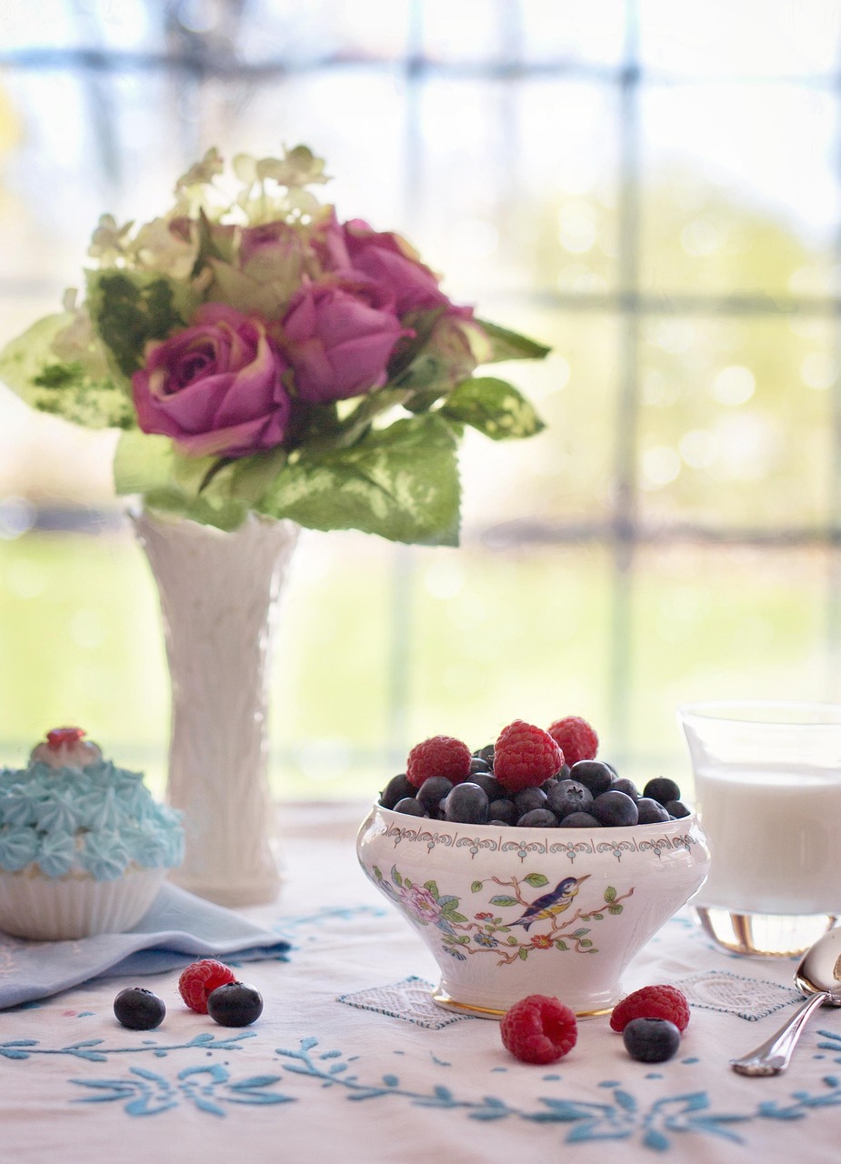 Bowl of fresh blueberries and raspberries on a wooden table - perfect for berry breakfast recipes