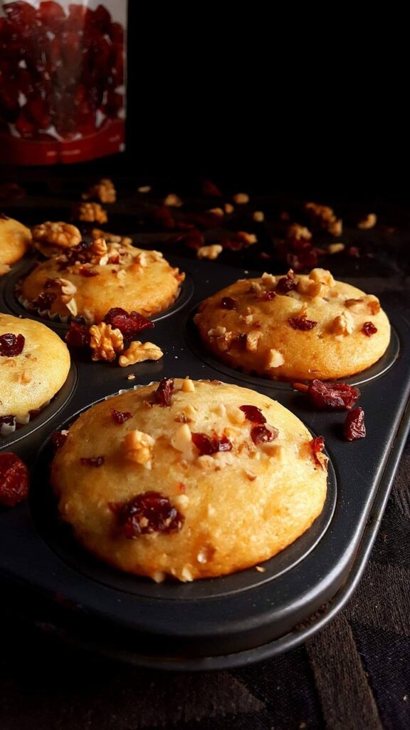 Freshly baked homemade high-protein muffins with cranberries and nuts on a baking sheet, perfect for healthy breakfast or snack meal prep