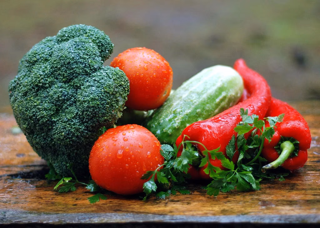 Colorful fresh vegetables with water droplets on a wooden table, representing the back-to-basics approach to healthy eating for longevity