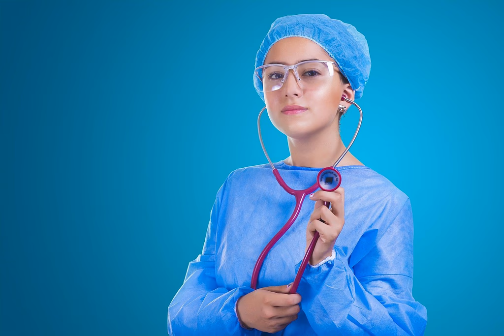 A woman doctor wearing a white coat and stethoscope, representing medical professionals whose likenesses can be targeted by AI deepfake videos used to promote unregulated supplements.