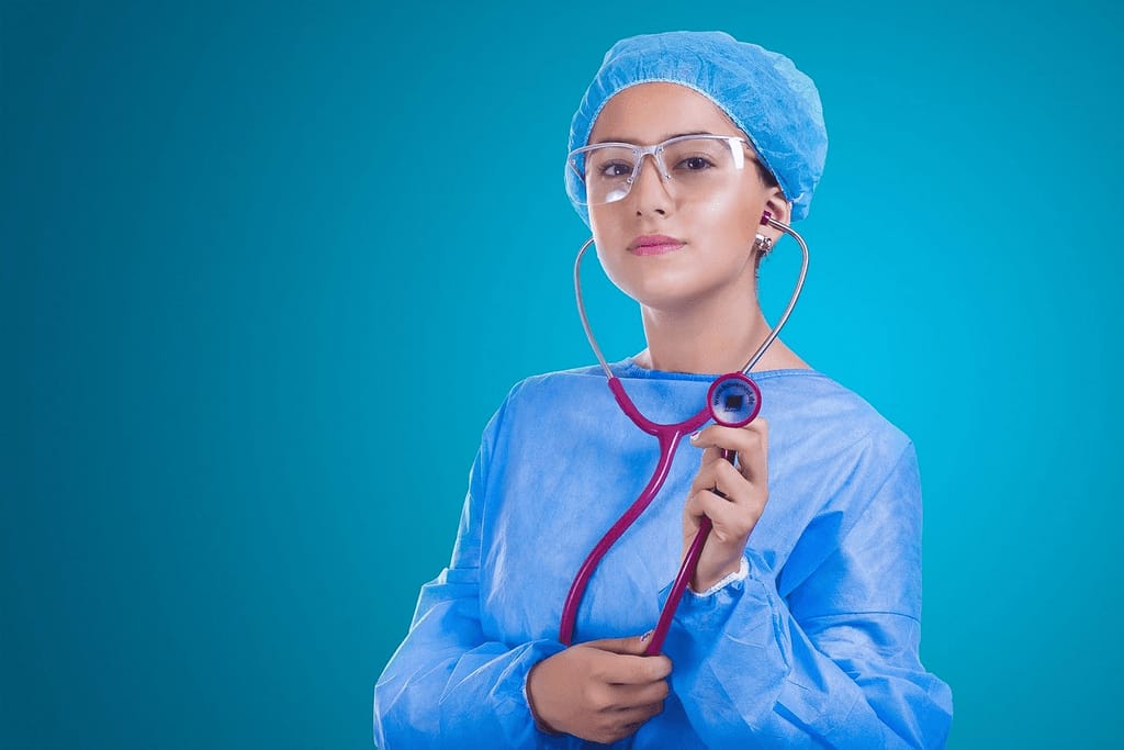 A woman doctor wearing a white coat and stethoscope, representing medical professionals whose likenesses can be targeted by AI deepfake videos used to promote unregulated supplements.
