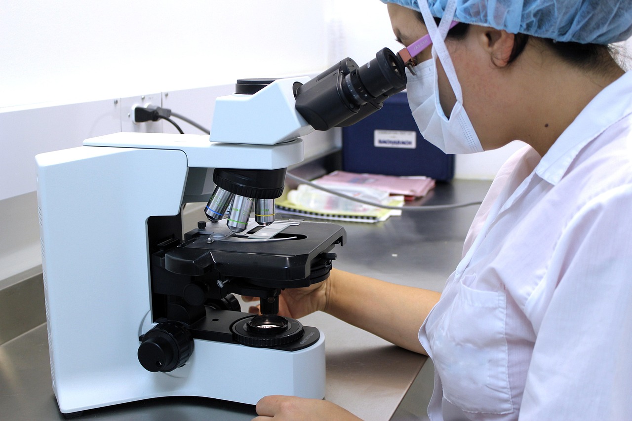 A person using a microscope in a laboratory setting, representing the scientific research behind new non-invasive endometriosis diagnostic tests