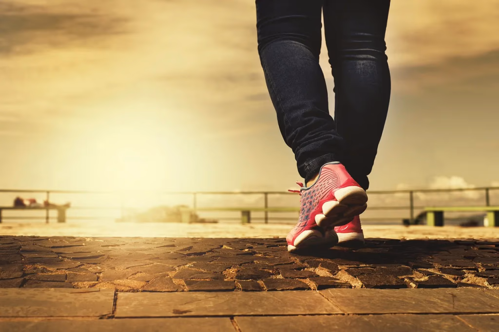 Woman wearing comfortable sneakers while walking on a scenic path, representing the best walking shoes for all-day pain-free comfort