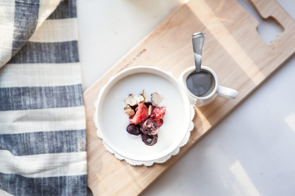 A nutritious breakfast bowl with yogurt, fresh fruit, nuts and milk, representing the soy milk vs dairy milk nutritional comparison
