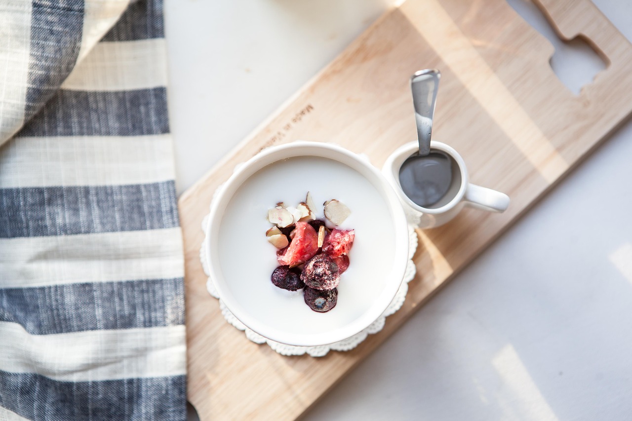 A nutritious breakfast bowl with yogurt, fresh fruit, nuts and milk, representing the soy milk vs dairy milk nutritional comparison