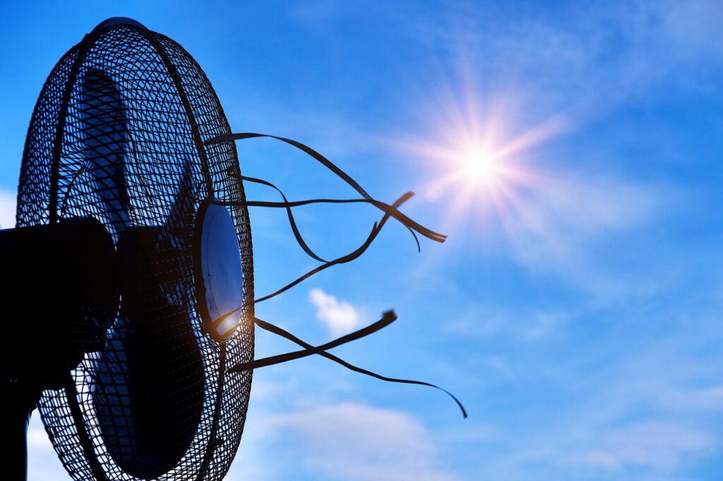 A conceptual image showing a sun and a fan representing overheating and cooling solutions for women experiencing hot flashes, night sweats, and temperature regulation issues