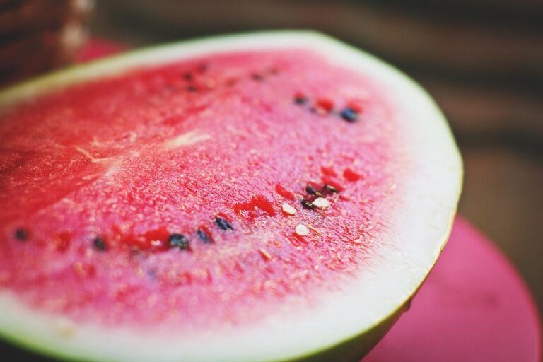 Fresh sliced watermelon on a white surface - a hydrating fruit rich in lycopene and water, ideal for sun exposure recovery after a long day in the heat