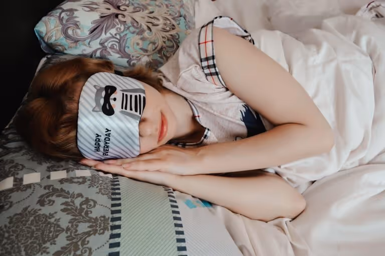 Woman sleeping peacefully wearing a silk sleep mask, representing deep sleep quality and its benefits for heart health and cardiovascular wellness