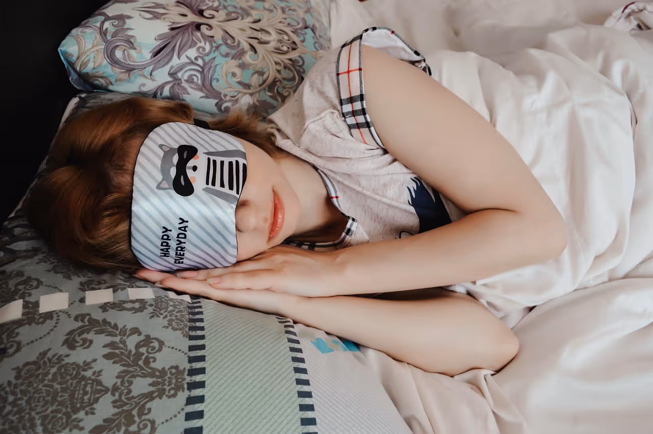 Woman sleeping peacefully wearing a silk sleep mask, representing deep sleep quality and its benefits for heart health and cardiovascular wellness