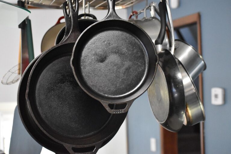 A black cast iron skillet on a stovetop containing golden pancakes with fresh berries and syrup, demonstrating a well-seasoned cast iron pan in use