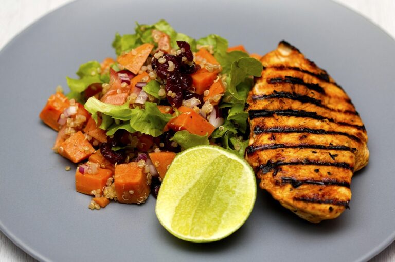 Grilled chicken quinoa salad with fresh vegetables on a wooden board - a high protein, high fiber dinner recipe