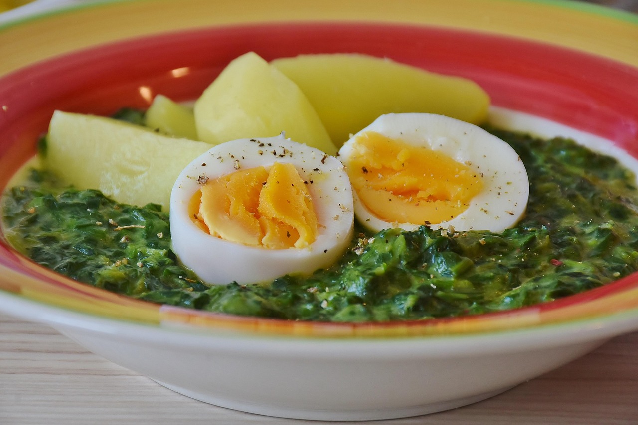 A delicious high-protein meal prep dish featuring eggs, spinach, and roasted potatoes on a plate, showcasing a healthy make-ahead meal option for busy weekdays.