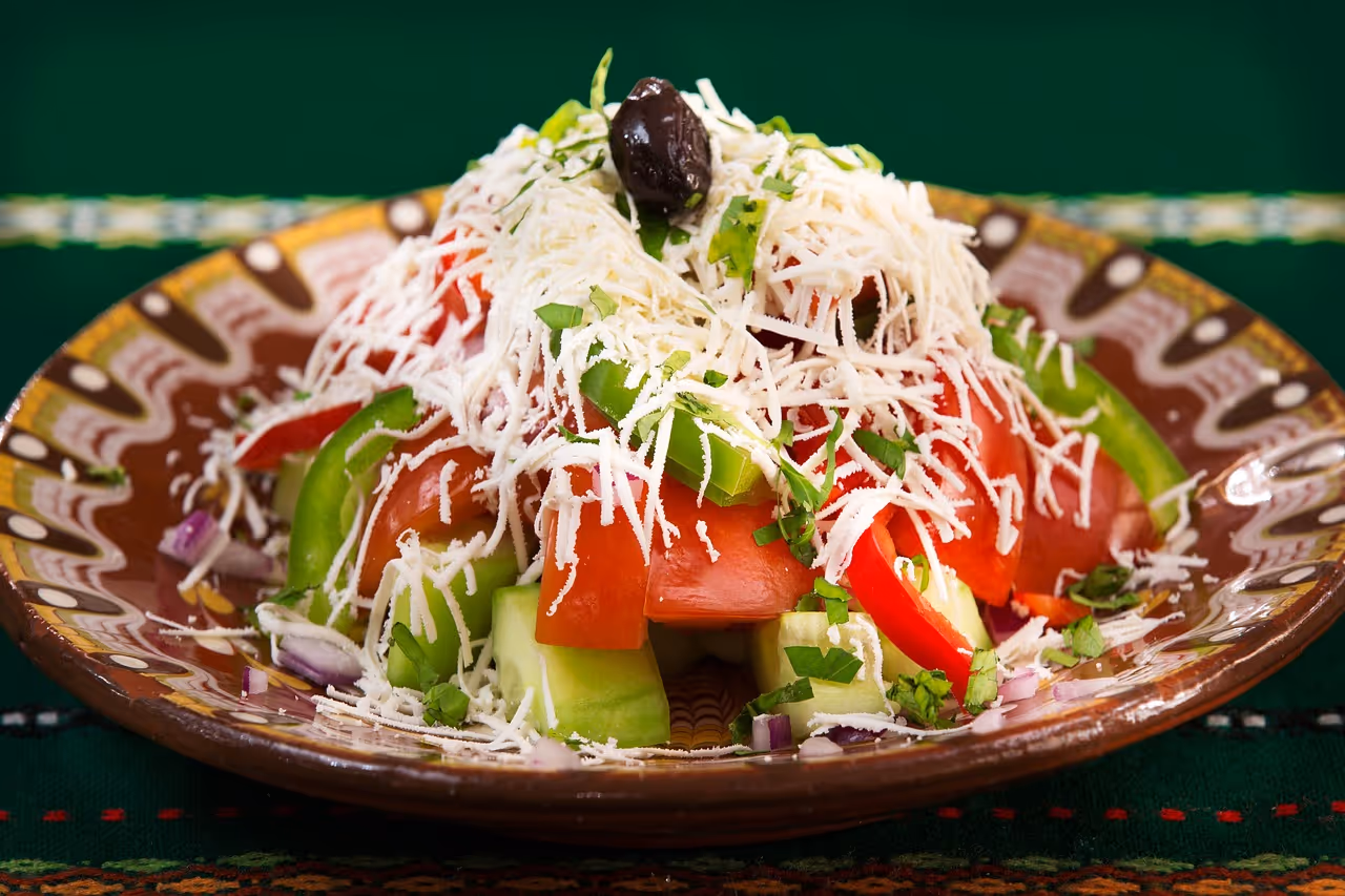 Fresh Mediterranean salad on a wooden table with cherry tomatoes, black olives, mozzarella cheese, and basil leaves — a healthy anti-inflammatory meal idea