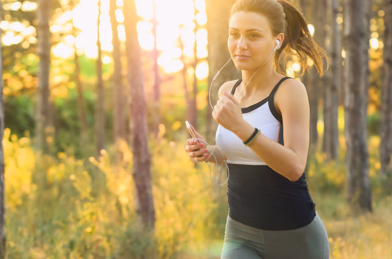 Young woman jogging outdoors with earphones, representing the active lifestyle and exercise routine recommended for maintaining weight loss results after stopping Ozempic or other GLP-1 medications