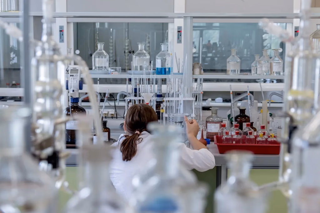 A chemist working in a laboratory with scientific equipment, representing the latest vitamin D research findings on blood levels, supplementation, and immune health.