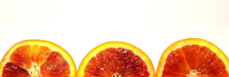 Fresh blood oranges on a dark surface - citrus fruits rich in potassium and antioxidants, part of a heart-healthy diet for supporting healthy blood pressure levels
