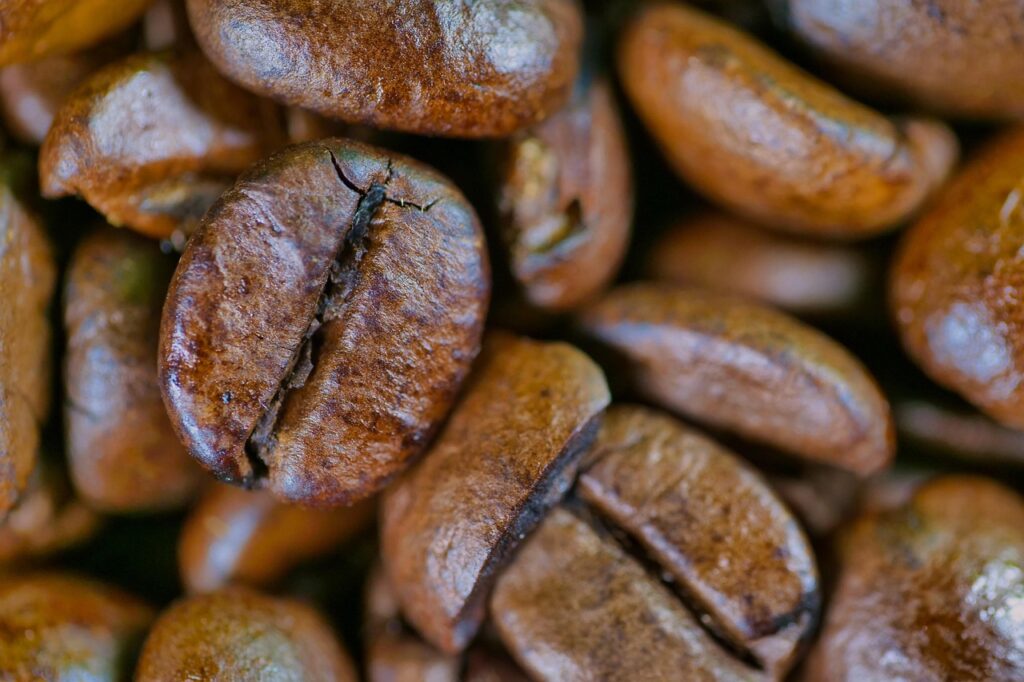 Close-up of roasted coffee beans representing caffeine as a pre-workout habit that works across all phases of the menstrual cycle