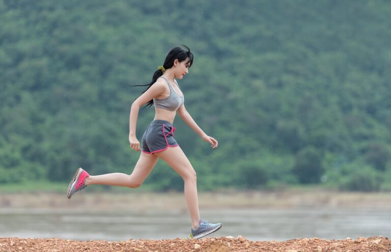Active woman in her 50s running outdoors in athletic clothing, representing high-intensity exercise and cardiovascular fitness after 50