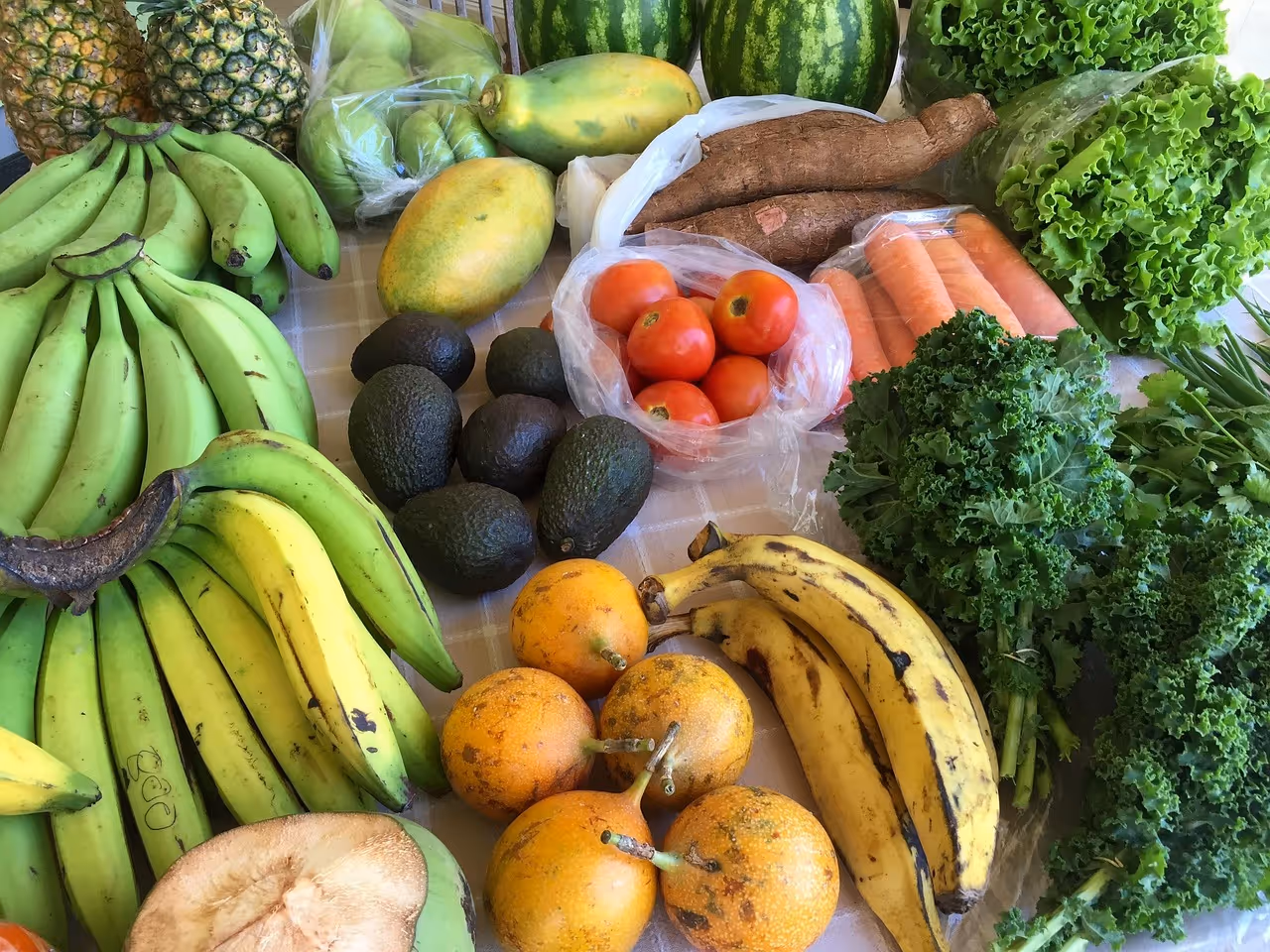 Colorful assortment of fresh fruits and vegetables on a wooden table, representing anti-inflammatory foods for a healthy grocery list including berries, citrus, leafy greens, and tomatoes