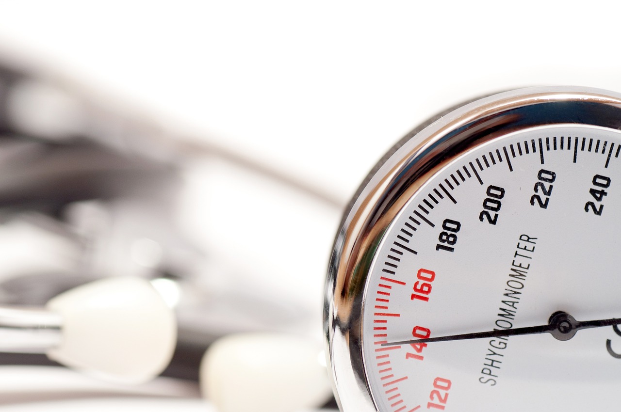 Close-up of a blood pressure sphygmomanometer gauge and cuff on a white background, representing hypertension management and monitoring for heart health.