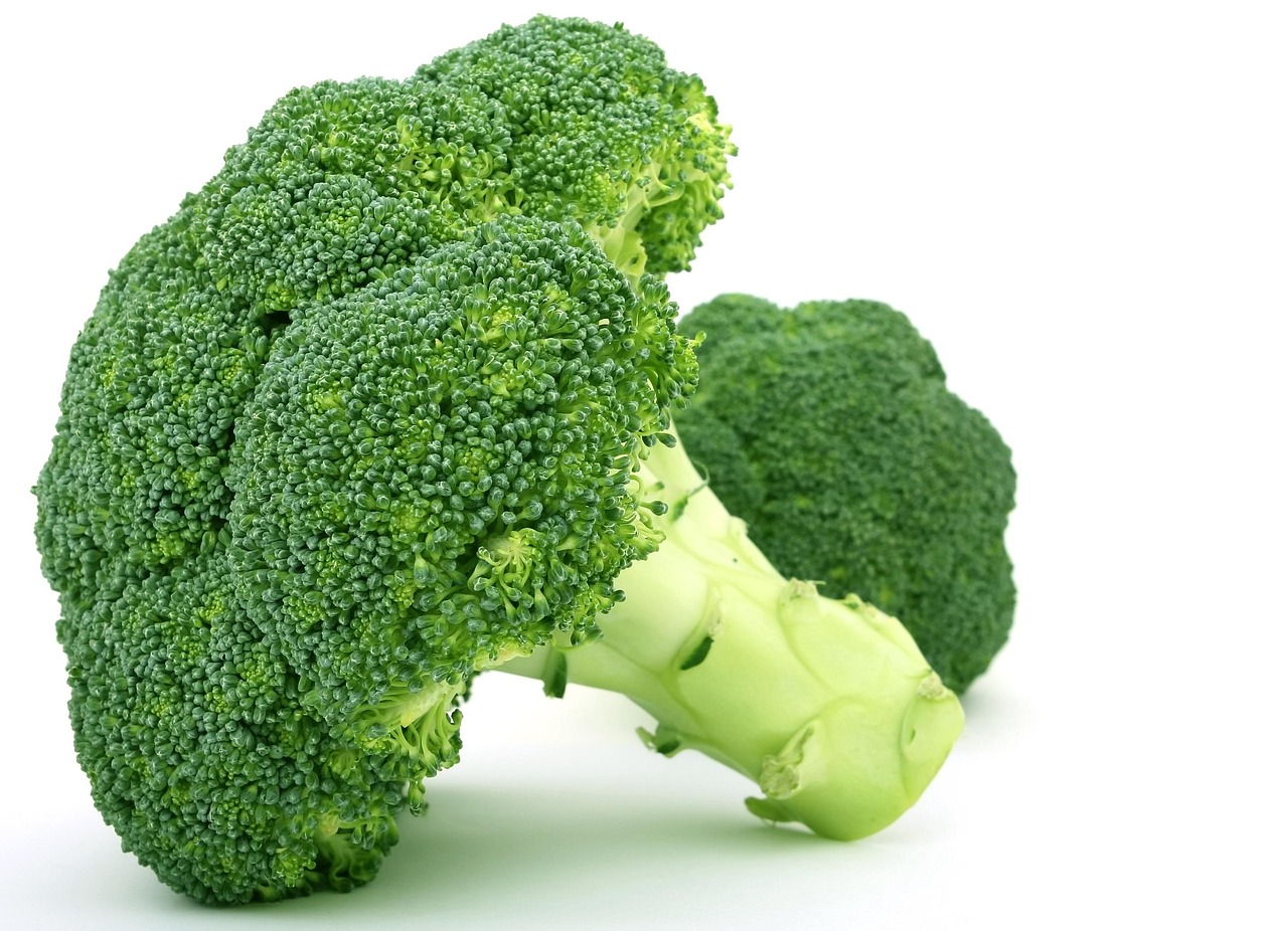 Fresh green broccoli florets on a wooden surface, a key high-fiber ingredient for healthy casserole dinners rich in gut-supporting nutrients.