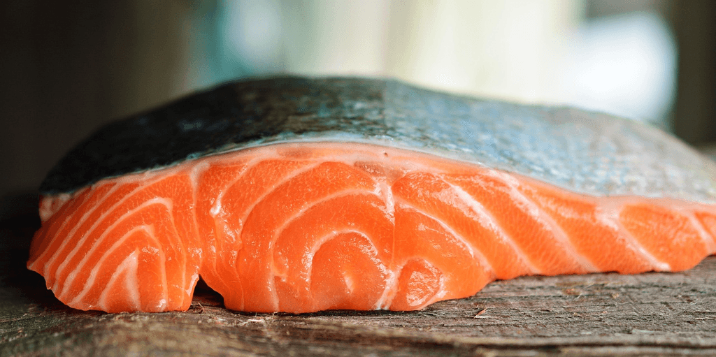 Close-up of a fresh raw salmon fillet with silver skin, representing the type of whole fish fillet recommended by dietitians for healthy fish sticks