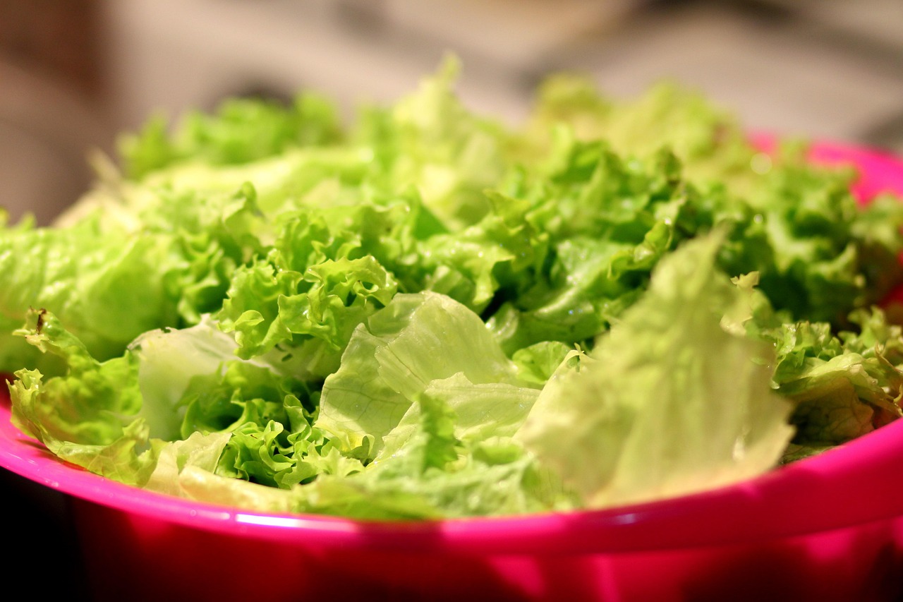 Fresh green lettuce leaves on a dark background, representing produce that may be linked to the 2026 cyclospora outbreak