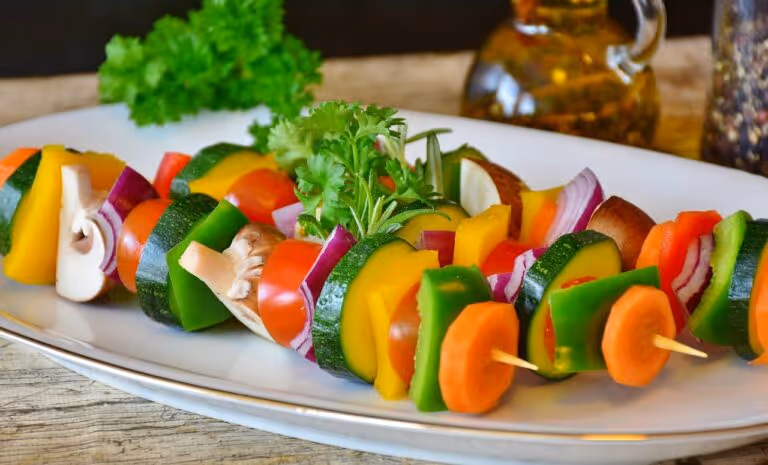 Colorful vegetable skewer with tomatoes, mushrooms, peppers and onions on a plate, representing healthy gut-friendly one-pot dinner ingredients