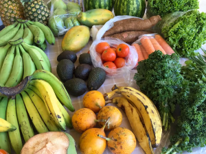 Vibrant assortment of fresh fruits and vegetables including leafy greens, avocados, bananas, and pineapples at a farmer's market - ideal for an anti-inflammatory diet rich in colorful produce