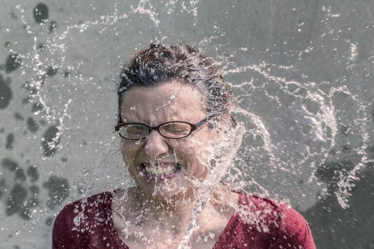 Woman splashing cold water on her face, demonstrating the temperature TIP distress tolerance skill that triggers the mammalian dive reflex to calm the nervous system