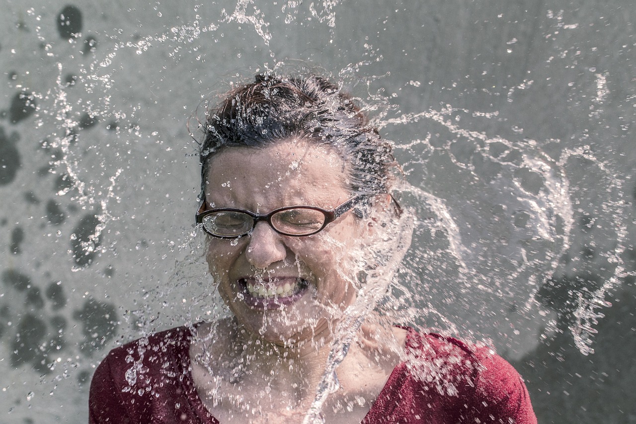 Woman splashing cold water on her face, demonstrating the temperature TIP distress tolerance skill that triggers the mammalian dive reflex to calm the nervous system