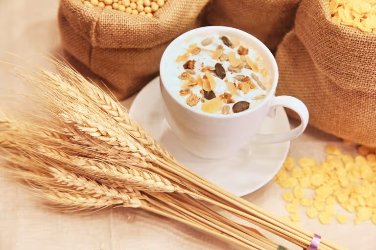 A bowl of muesli or cereal with grains, dried fruits and seeds on a wooden table, representing a healthy high-fiber breakfast option