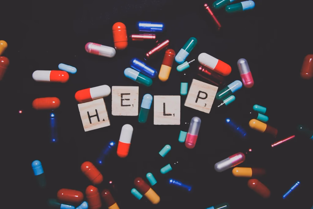 A flat lay of assorted colorful pills and capsules spilling from a prescription bottle, representing antidepressant medications and the concept of deprescribing and safe medication management.