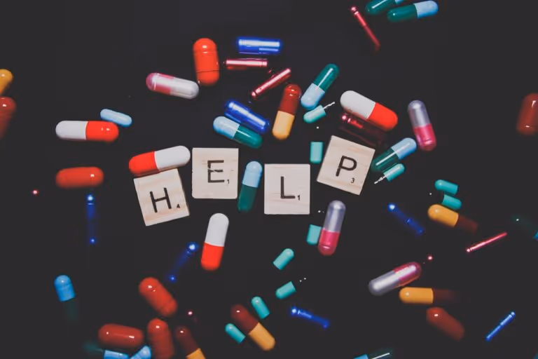 A flat lay of assorted colorful pills and capsules spilling from a prescription bottle, representing antidepressant medications and the concept of deprescribing and safe medication management.