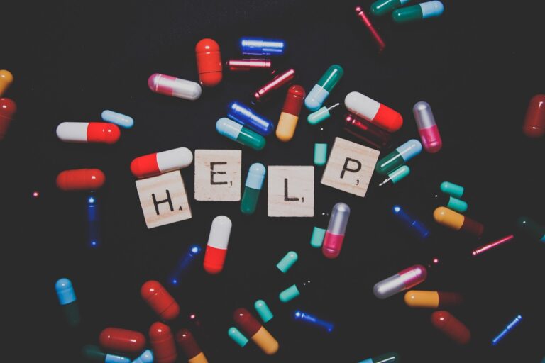A flat lay of assorted colorful pills and capsules spilling from a prescription bottle, representing antidepressant medications and the concept of deprescribing and safe medication management.