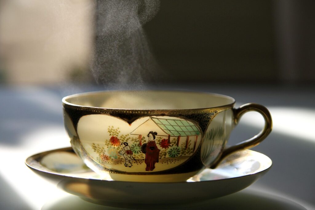 Steaming cup of green tea on a table, representing the best tea for kombucha brewing with green and oolong tea varieties