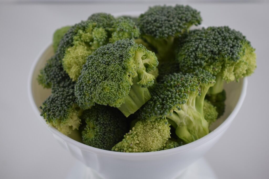 Fresh green broccoli florets arranged in a white bowl, perfect for healthy broccoli salad recipes with nutritious cruciferous vegetables