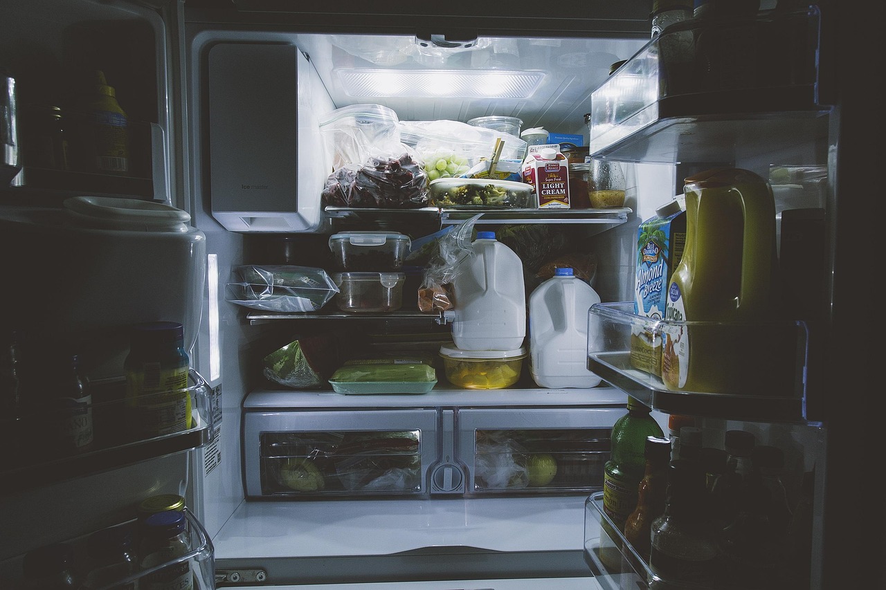 Glass bottles and food containers arranged on a refrigerator shelf, representing safe breast milk storage practices for breastfeeding mothers