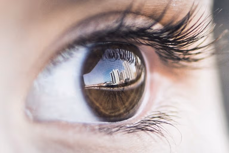 Close-up macro photograph of a human eye with a reflection, representing vision, eye health, and the new vitamin A discovery about cone cell development in the retina.