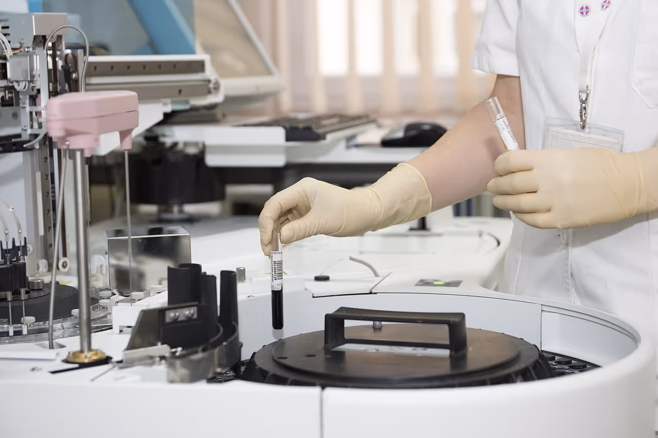 A medical professional in a white lab coat and blue gloves holds test tubes and vials in a laboratory setting, representing the scientific and medical applications of Botox beyond cosmetic use