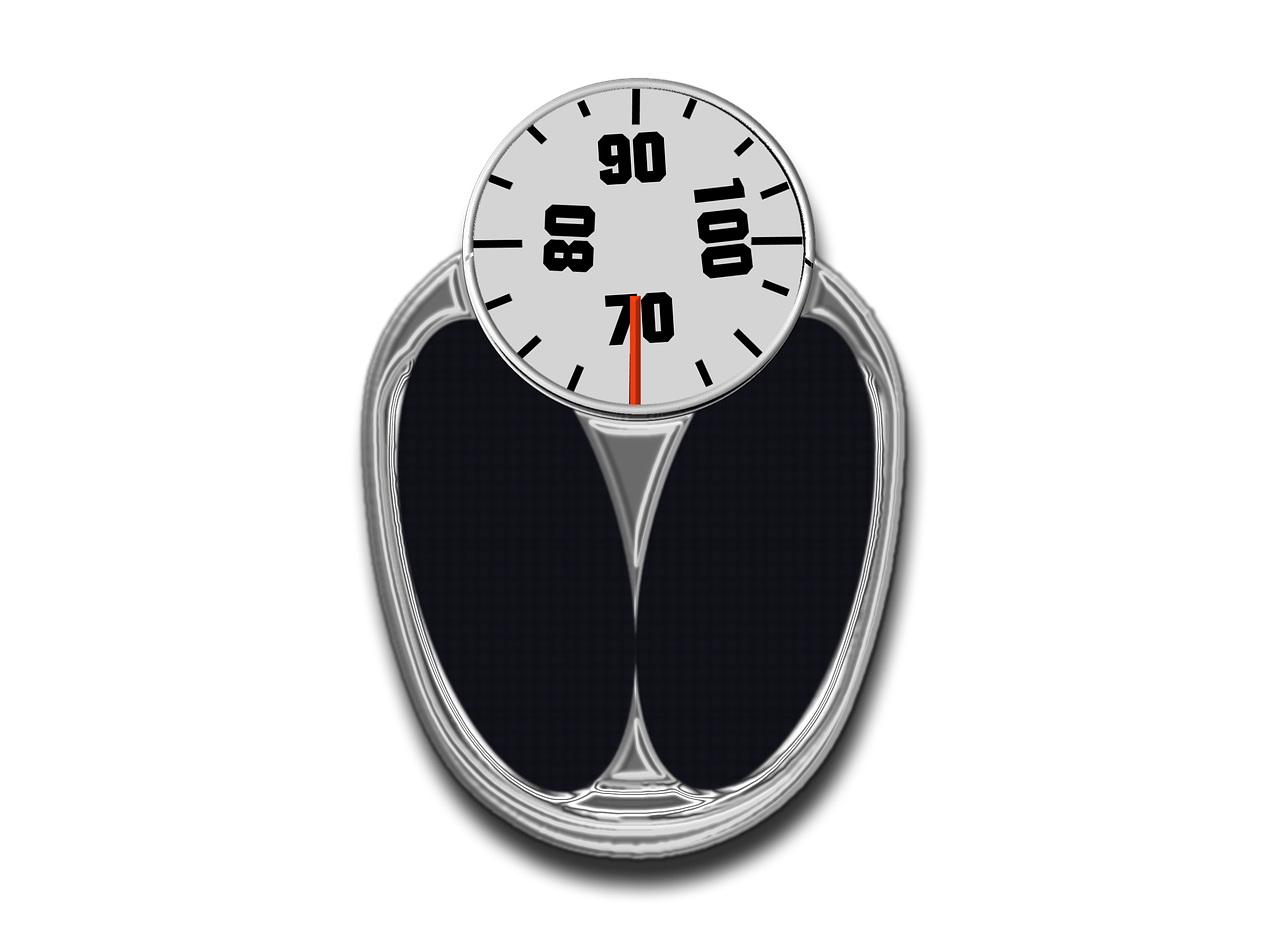 A white bathroom scale on a wooden floor, representing weight control and the connection between sleep and weight gain.