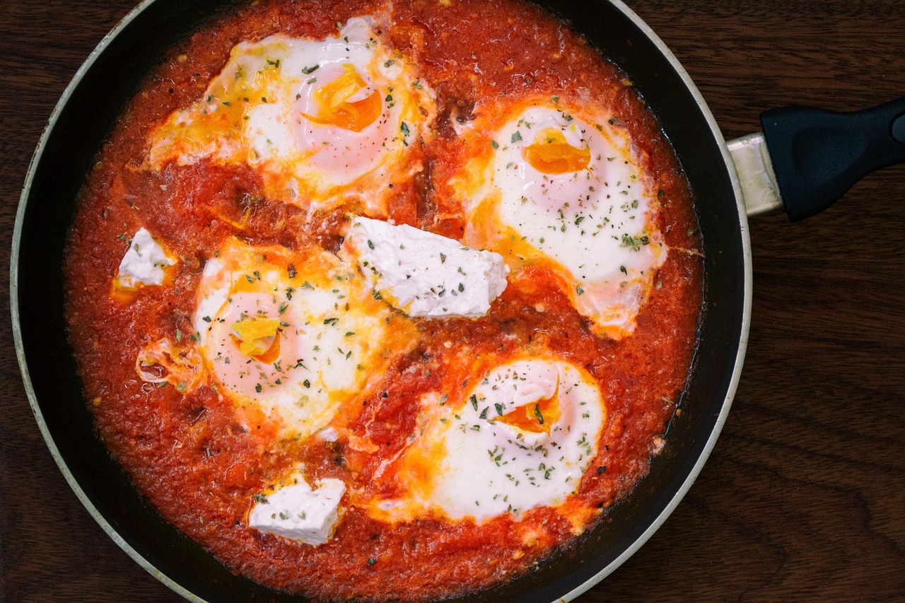 A delicious skillet dish of eggs poached in rich tomato sauce with herbs and feta cheese, perfect for quick tomato recipes ready in 15 minutes or less