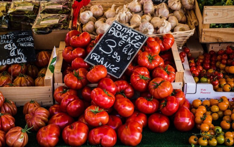 Fresh tomatoes, garlic, and greens at a summer market representing Aldi's budget-friendly summer grocery finds for healthy no-cook eating.