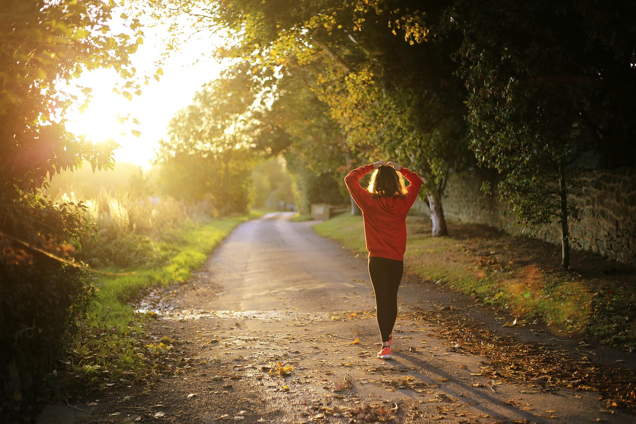 Woman walking on a path at dawn as a natural way to boost mental energy and cognitive function through exercise